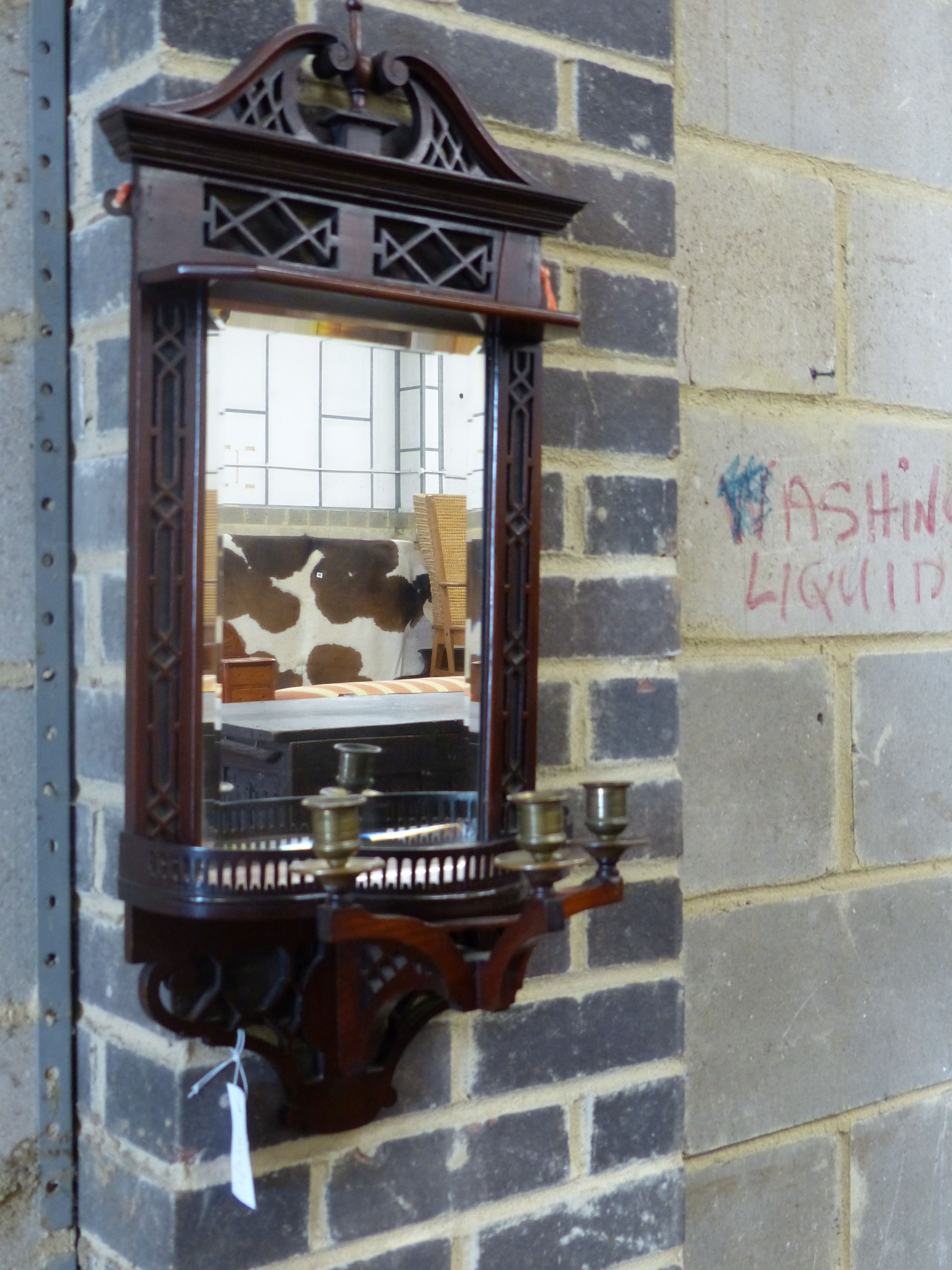 An Edwardian mahogany mirrored wall bracket with triple brass sconce, width 31cm height 75cm